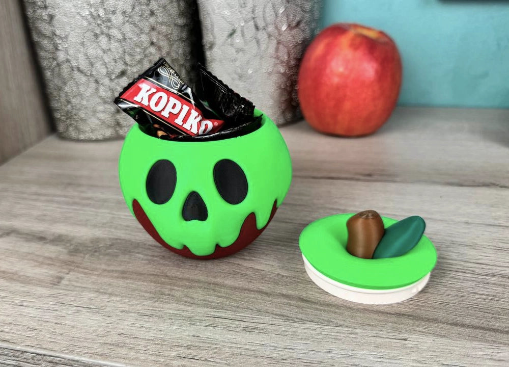Schneewittchens vergifteter Apfel Süßigkeitenschale mit einer Schokoladentafel obenauf und dem Deckel mit Süßigkeiten daneben - Kokoroto