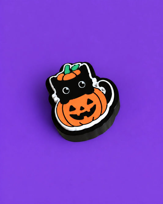 Halloween-Kätzchen-Schlüsselanhänger-Clicker im Kürbiskostüm, vor violettem Hintergrund - Kokoroto