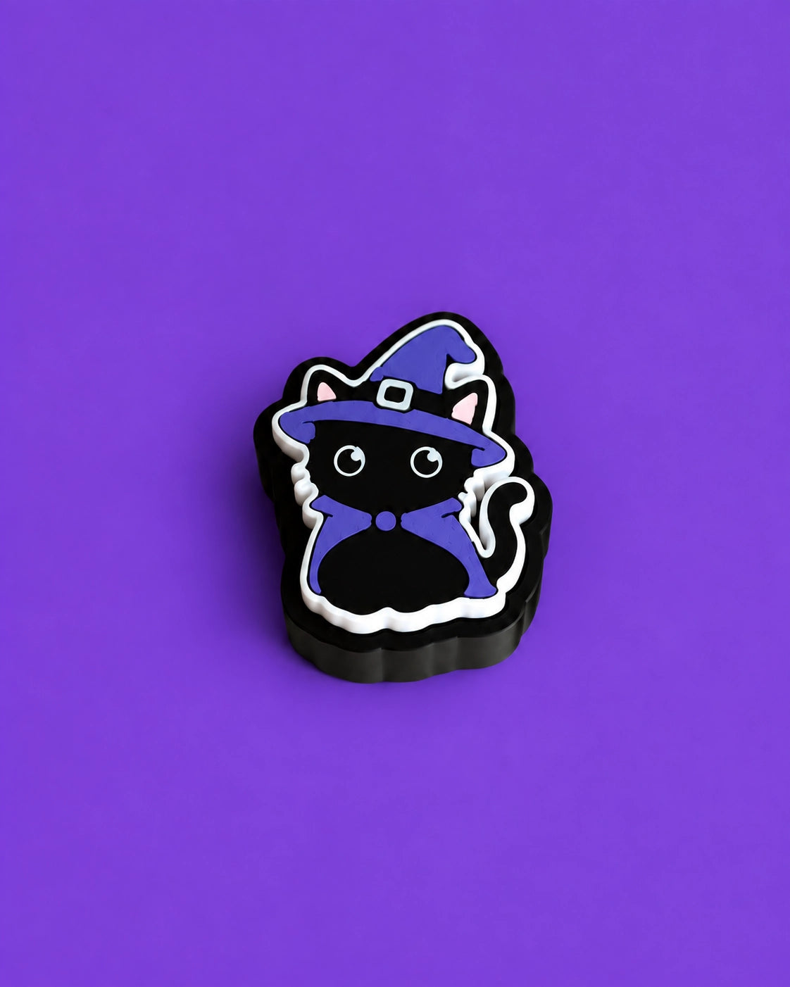 Halloween-Kätzchen-Schlüsselanhänger-Clicker im Hexenkostüm, vor violettem Hintergrund - Kokoroto