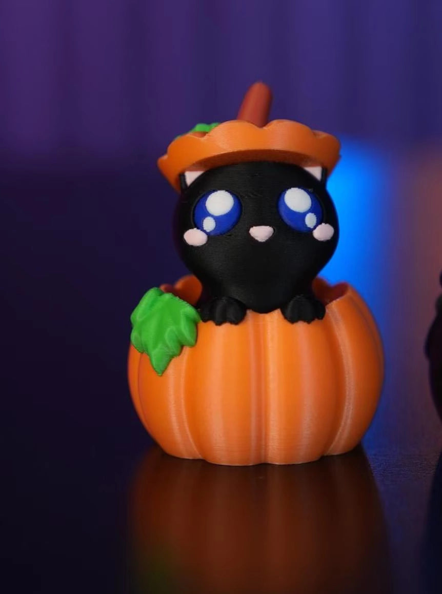 Detailansicht des Halloween-Schlüsselanhänger-Clickers in Form eines Kätzchens, das mit großen Augen aus einem Kürbis herausschaut - Kokoroto