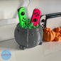Witch's cauldron for Joy-Con in gray with the green and pink controllers placed inside the green interior - Kokoroto