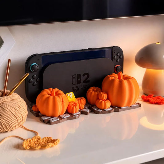 Halloween Dock mit Kürbissen für Nintendo Switch 2, mit eingesetzter Konsole, neben einem Wollknäuel und einer pilzförmigen Lampe - Kokoroto